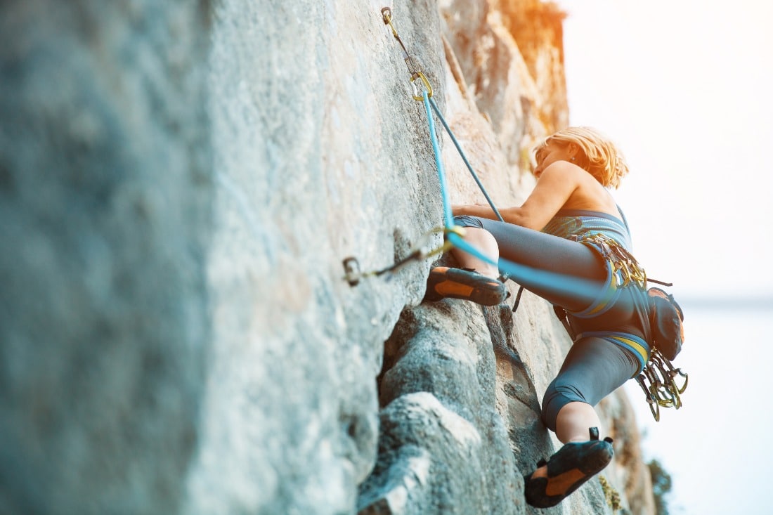 female rock climber on wall shot from below