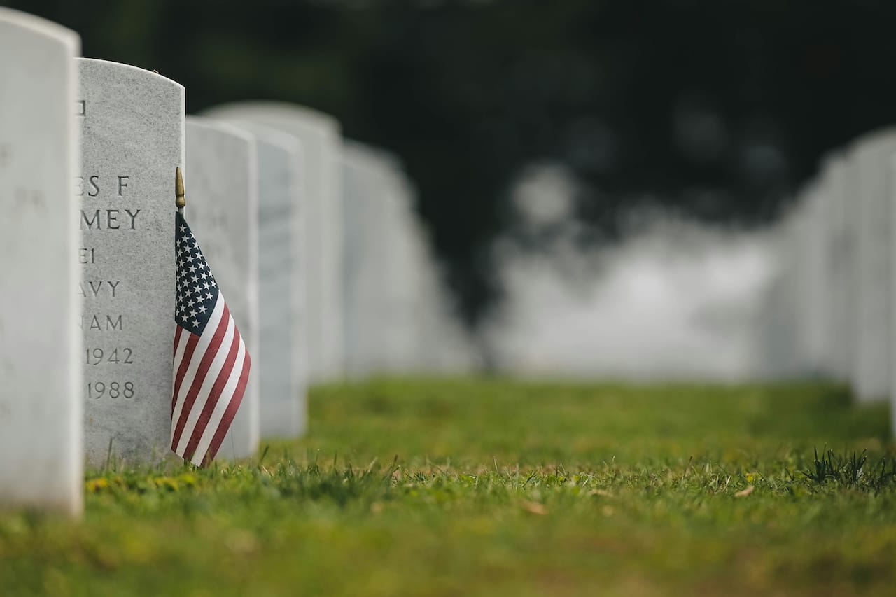 pexels-chad-madden-3009304-8050336 American Flag Near the Tombstone on the Green Grass