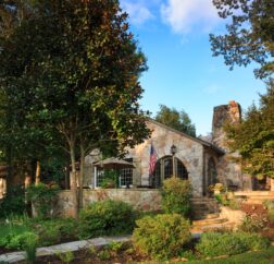 The front of the Chanticleer Inn shows a well landcaped lawn leading up to the stone covered B&B.