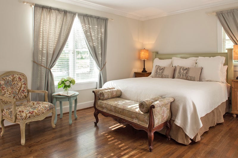 view of king-size bed next to large window in Room 11